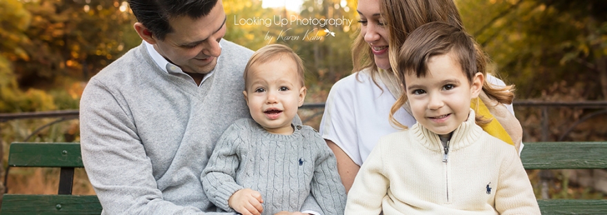 Precious moment with baby brother in an outdoor fall session with family of four with gorgeous yellow and orange fall colors for a posed family portrait