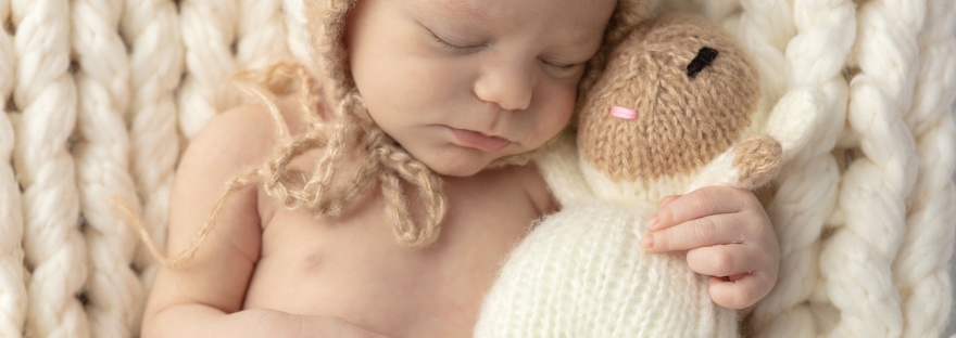 newborn baby boy snuggling a wool sheep; Connecticut newborn photographer